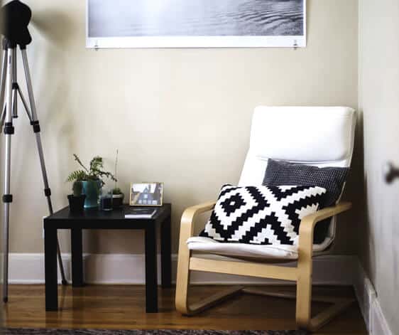 a chair and a small table on the corner of a room