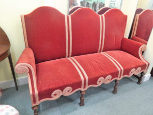 A Red Cushioned Sofa on a Carpet Image