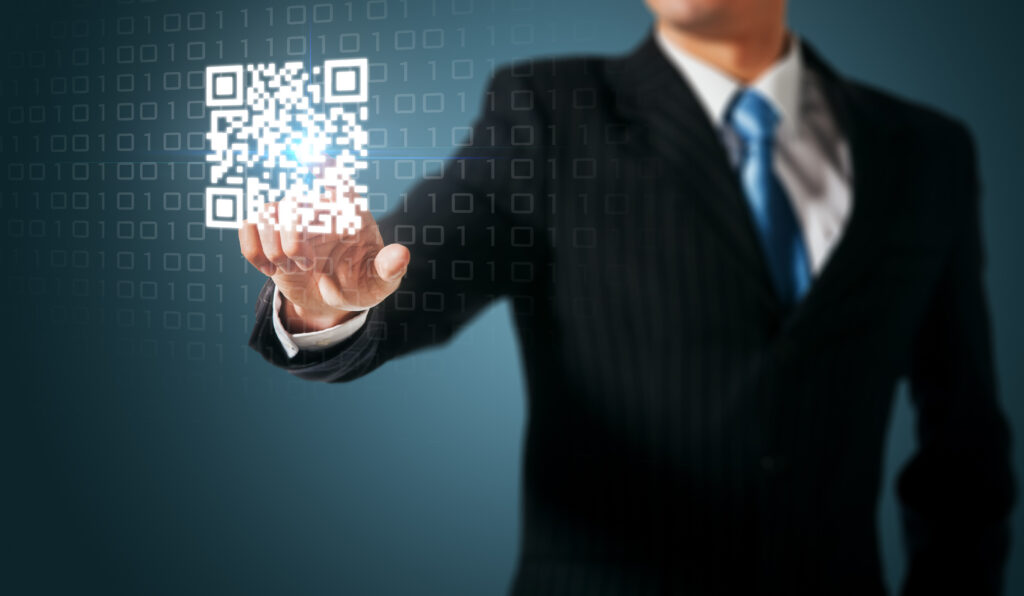 a man in suit pointing at a QR code