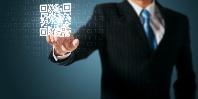 a man in suit pointing at a QR code