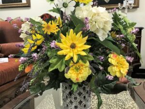 a vase with synthetic flowers on a table