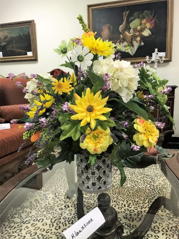 a vase with synthetic flowers on a table