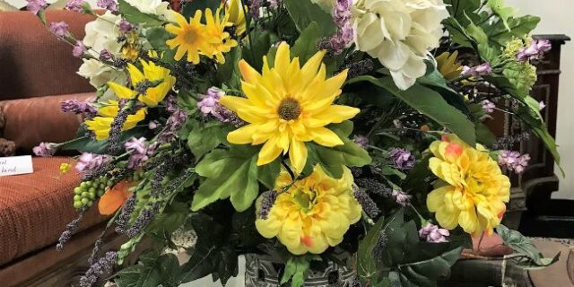 a vase with synthetic flowers on a table